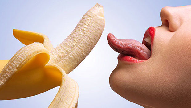 Woman tongue licking banana