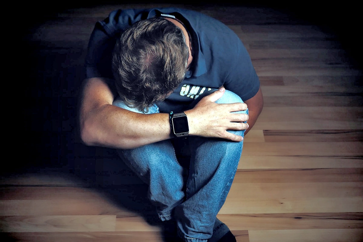 Man with depression sitting on the floor